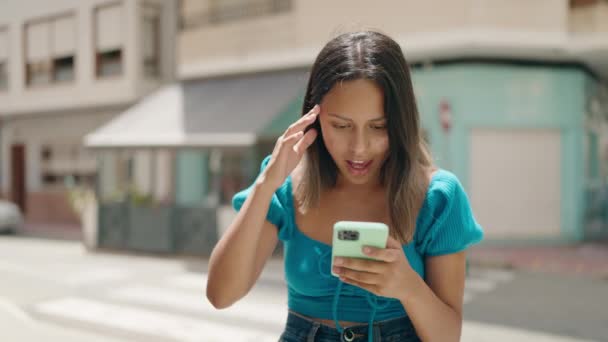 Young Hispanic Woman Using Smartphone Surprise Expression Street — Stock video