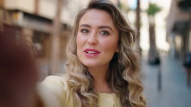 Genç sarışın kadın gülümsüyor. Kendine güveni tam.