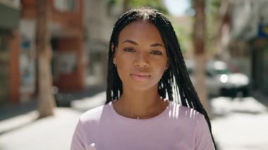 African american woman smiling confident wearing summer hat at street
