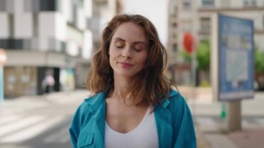 Sokakta saçları tarayan genç bir kadın.