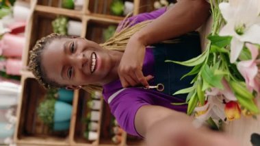 Afrikalı Amerikalı kadın çiçekçinin çiçekçide dikey video görüntüsü var.