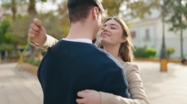 Young couple smiling confident surprise with flower at park