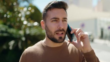 Genç İspanyol adam gülümsüyor. Kendine güveniyor. Sokakta akıllı telefondan konuşuyor.