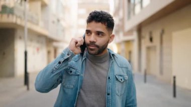Sokakta akıllı telefondan konuşan genç adam.