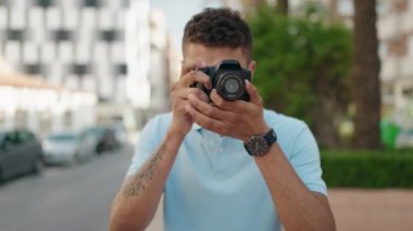 African american man smiling confident using professional camera at park