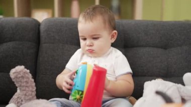 cute baby girl sitting on the floor of the toy game, playing with toys