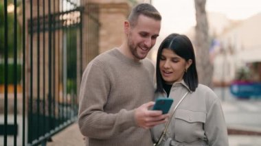 Young couple smiling confident make selfie by the smartphone at street