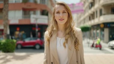 Sarışın, sarı gömlekli, beyaz elbiseli güzel bir kadın.