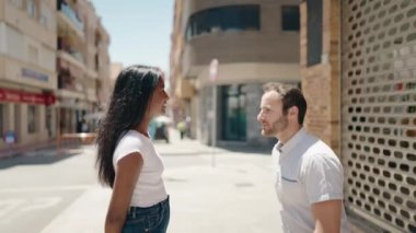 Man and woman interracial couple having engagement proposal at street