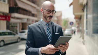 businessman in suit and eyeglasses looking at camera while standing in front of modern office building