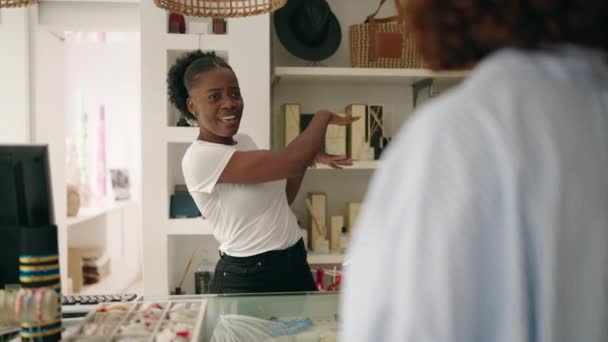 アフリカ系アメリカ人女性ショップのアシスタントと衣料品店で話す顧客 — ストック動画