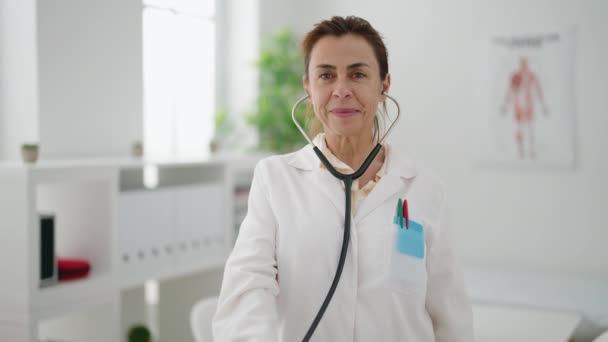 Frau Mittleren Alters Arztuniform Hält Stethoskop Klinik — Stockvideo