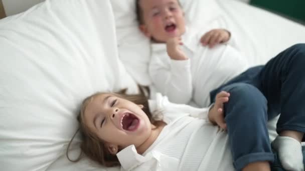 Αξιολάτρευτο Κορίτσι Και Αγόρι Ξαπλωμένοι Στο Κρεβάτι Ουρλιάζοντας Και Κλωτσώντας — Αρχείο Βίντεο