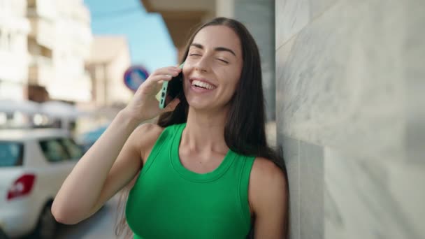 若い美しいですヒスパニック女性笑顔自信を持って話して上のスマートフォンで通り — ストック動画