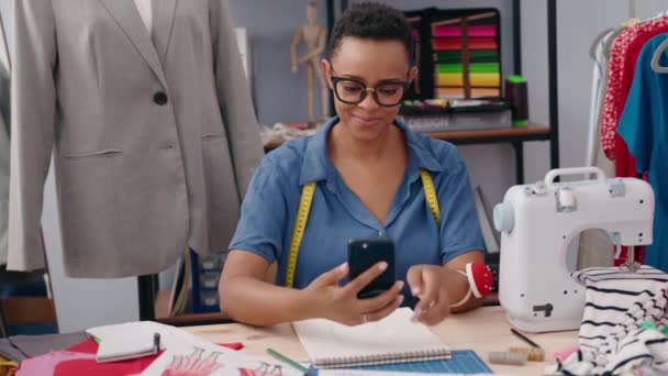 非洲裔美国妇女裁缝笑着自信地在裁缝店用智能手机自拍 — 图库视频影像