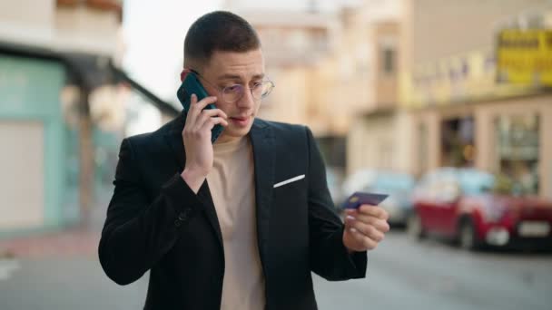 Young Hispanic Man Executive Talking Smartphone Holding Credit Card Street — Stockvideo
