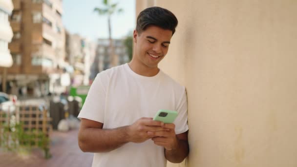 Ung Latinamerikansk Man Ler Säker Med Hjälp Smartphone Gatan — Stockvideo