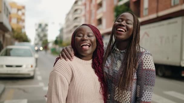 2人のアフリカ系アメリカ人女性が自信を持って通りで抱き合って笑っています — ストック動画
