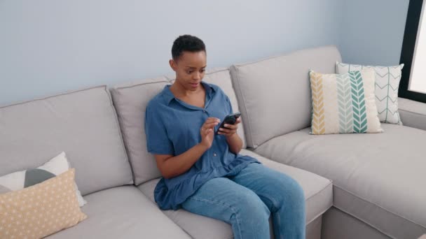 Young African American Woman Using Smartphone While Sitting Sofa Home — Αρχείο Βίντεο