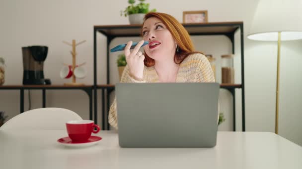 Giovane Rossa Donna Utilizzando Computer Portatile Parlando Sullo Smartphone Casa — Video Stock