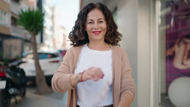 中年妇女微笑着 自信地站在街头 双手交叉地摆出姿势 — 图库视频影像