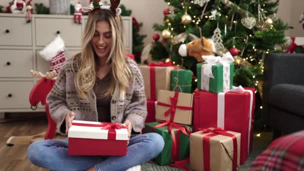 暖炉を背景にクリスマスの贈り物を持つ美しい若い女性 — ストック動画