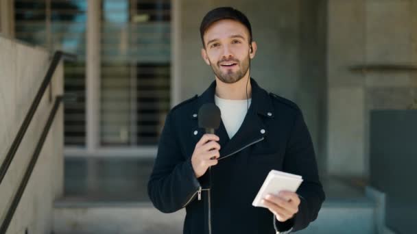 Young Hispanic Man Reporter Working Using Microphone Street — Αρχείο Βίντεο