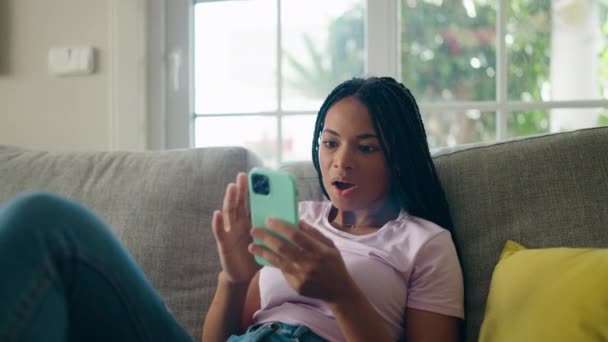 Afrikansk Amerikansk Kvinna Använder Smartphone Med Glada Uttryck Hemma — Stockvideo