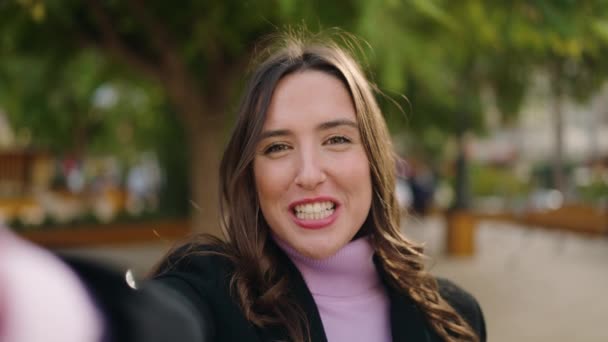年轻的惊慌失措的女人带着自信的笑容在公园里打电话 — 图库视频影像