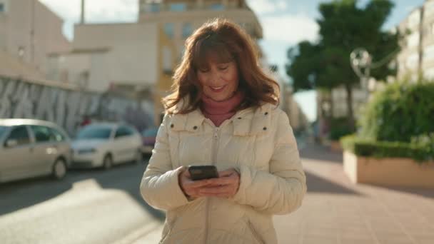 Rothaarige Frau Mittleren Alters Lächelt Selbstbewusst Mit Smartphone Auf Der — Stockvideo