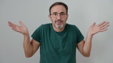 İzole edilmiş beyaz arka planda şüpheli bir ifadeyle duran orta yaşlı bir adam.