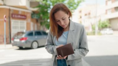 Young woman executive holding empty wallet at street