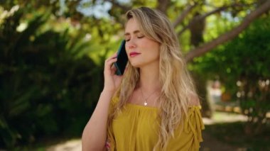 portrait of a beautiful young woman with a blond hair in a green dress on a background of a summer