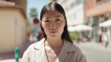 Sokakta kendinden emin gülümseyen Çinli kadın.