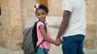 happy african-american boy and girl with backpack and backpacks standing in the corridor