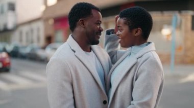 African american couple smiling confident hugging each other and speaking at street