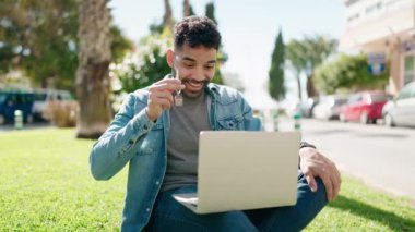 Young arab man holding key having video call at park