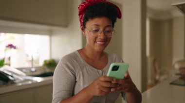 African american woman using laptop and smartphone at home