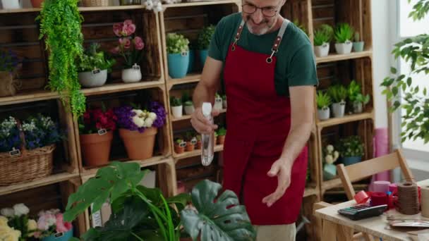 Çiçekçide Çalışan Orta Yaşlı Bir Çiçekçi Dağıtıcı Kullanıyor — Stok video