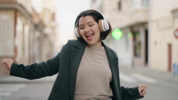年轻的惊慌失措的女孩带着自信的笑容在街上听音乐 — 图库视频影像