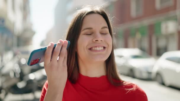 Młoda Kobieta Uśmiecha Się Pewnie Słuchając Wiadomości Audio Przez Smartfona — Wideo stockowe