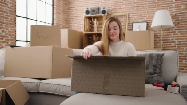 Young Blonde Woman Smiling Confident Unboxing Package New Home — Stock Video