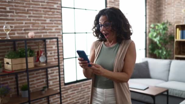 Middle Age Hispanic Woman Using Smartphone Celebrating — Vídeos de Stock