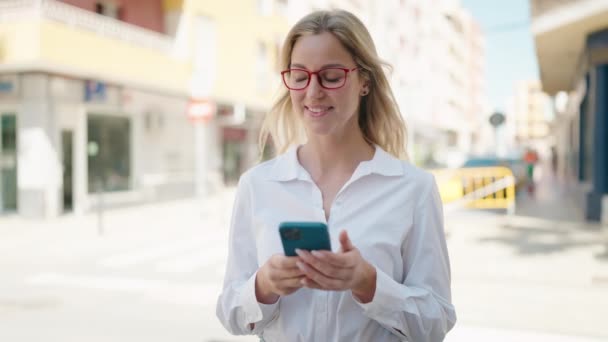 Young Blonde Woman Smiling Using Smartphone Street — Stockvideo