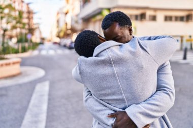 Man and woman couple hugging each other standing at street