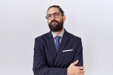 Hispanic man with beard wearing suit and tie skeptic and nervous, disapproving expression on face with crossed arms. negative person. 