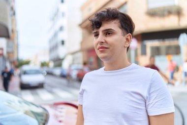 Non binary man looking to the side with serious expression at street