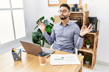 Genç Arap adam ofiste yoga yaparken rahatlamış.