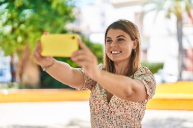 Young woman smiling confident making selfie by the smartphone at park