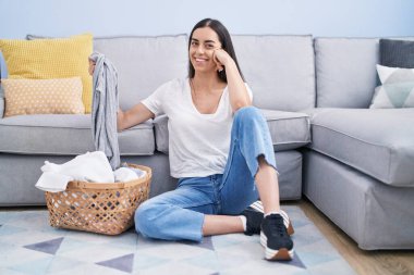 Young brunette woman doing laundry at home smiling with a happy and cool smile on face. showing teeth. 